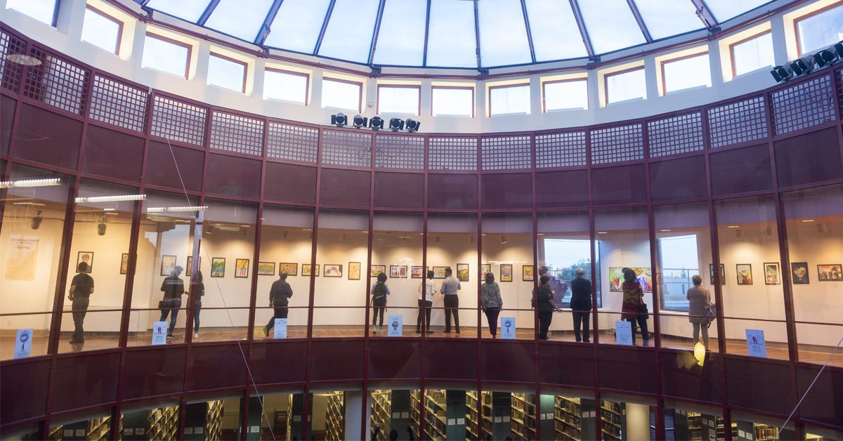 Visitors viewing an art exhibition inside the Benjamin Rosenthal Library.